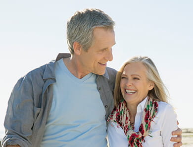 happy mature couple enjoying summer vacation on beach